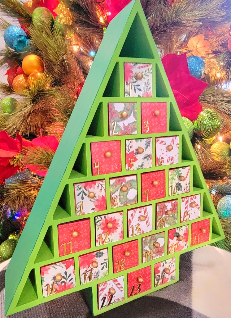 Decorated wooden advent tree with print and braille numbers.