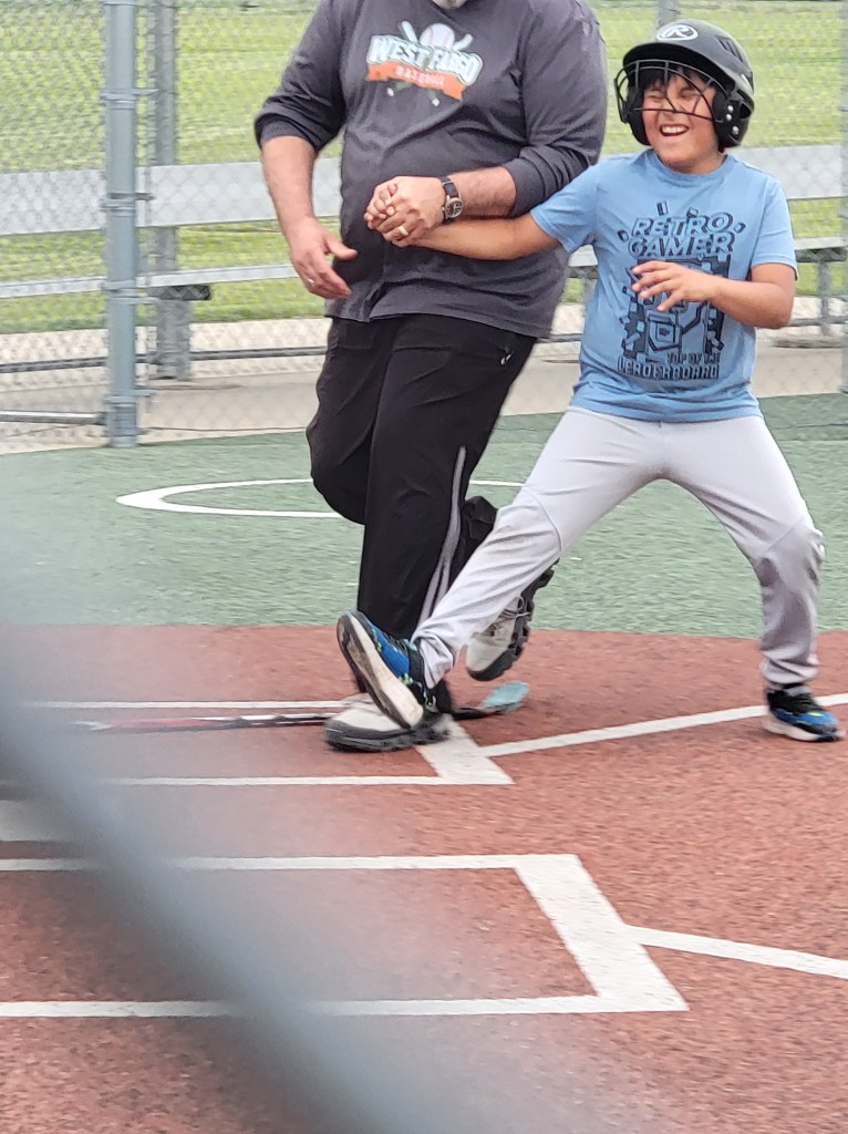 Boy being guided to home by his father. The boy is wearing a huge grin.